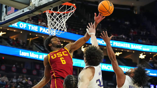 USC's Bronny James battles for a rebound with the UW's Braxton Meah and Sahvir Wheeler.